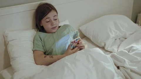 Child with smartphone before bedtime.	 Stock Footage 311806211