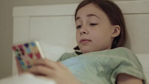 Child with smartphone before bedtime.	 Stock Footage 311806309