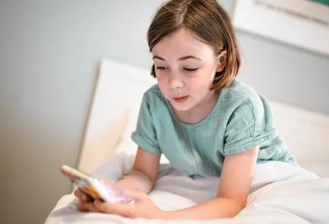 Child with smartphone before bedtime... Stock Photos