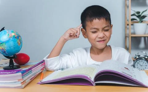 The child smile thinking sitting at table with book. Education, Childhood, .. Stock Photos