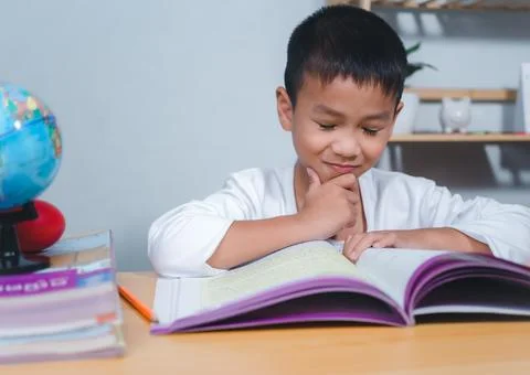 The child smile thinking sitting at table with book. Education, Childhood, .. Stock Photos