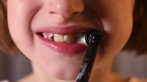 Child smiles, showing missing and growing teeth, then brushes teeth with Stock Footage 309620370