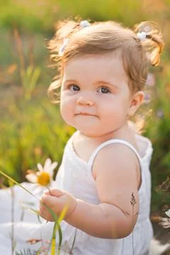 The child is smiling happily while sitting in the field 3017. Stock Photos