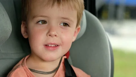 Child smiling while sitting in car seat Stock Footage 136644395