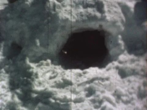 Child in snowsuit climbing out of igloo - vintage 8mm Stock Footage 78933807