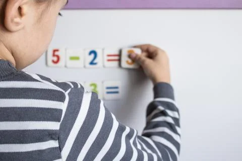 A child solves examples on a blackboard. The boy solves mathematical examples Stock Photos