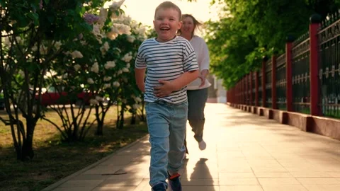 Child son plays with mom run together park spring. Family run. Happy family Stock Footage 335415623
