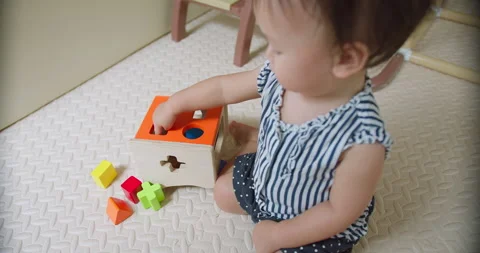 Child Sorting Colorful Blocks Toddler Sitting On Playmat in Focused Child Stock Footage 332166367