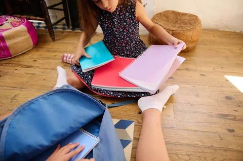 Child Sorting Notebooks on Floor Stock Photos