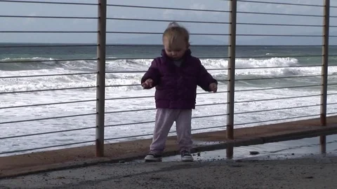 Child splashes in puddle by the sea Stock Footage 78322996