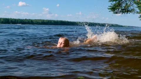 A child splashes in the river in summer Stock Footage 313599233