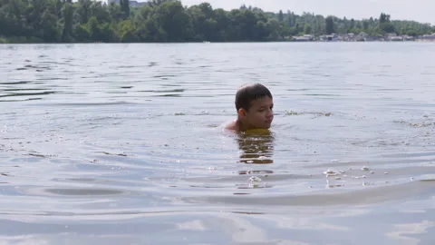Child Splashes in the Water, the River, Creating Waves, Splashes, Whirlpools. 4K Stock Footage 157805142