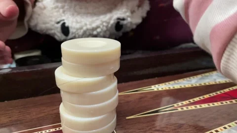 A child stacking backgammon stone on top of each other Stockbeeldmateriaal 272321058