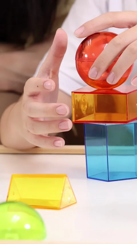 Child Stacking Colorful Transparent Blocks in Classroom Activity Stock Footage 323679718