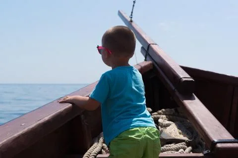 The child standing on the bow of the ship Stock Photos