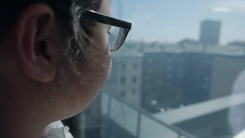A child stands against the background of a panoramic window 스톡 동영상 156521939