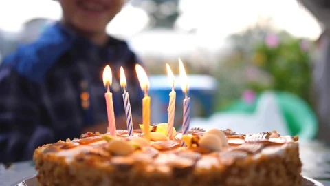 The child stands in background the cake on his birthday. Children's holiday Vidéo 115180346