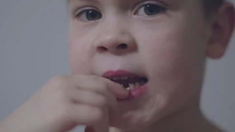 Child stands joyfully revealing missing baby tooth in bright,close-up shot Stock Footage 295002948