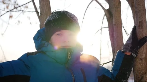 A child stands near a tree on the background of sunlight . Winter landscape Vidéo 72536693
