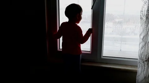 Child staring out the window,it is dangerous for children to stay in the window Video stock 106688958