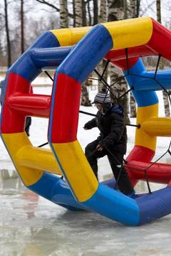 The child steps inside a large colored rubber wheel Stock Photos