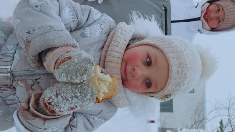 A child on the street eats bread in winter Stock Footage 265012624