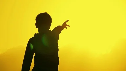 Child stroking the sun, warming his hands on a warm sunset Video stock 75714083