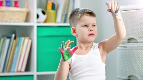 A child student is drawing something using a paintbrush and his hands 動画素材 102820446