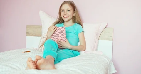 Child student sitting on the bed and opens a notebook. Something writing Video stock 76244681