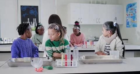 Child students lab bench examining test tubes while teacher entering with tablet Stock Footage 340654176
