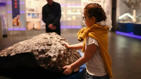 A child studies an exhibit in a museum, a planet Earth, meteorite Stock Footage 269870149