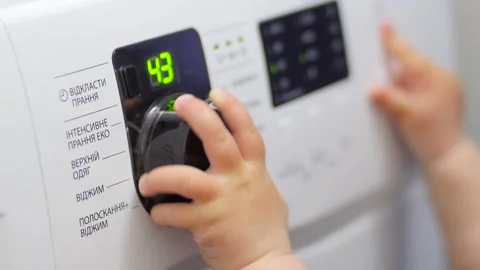 A Child Studies a Washing Machine Stock Footage 130404326