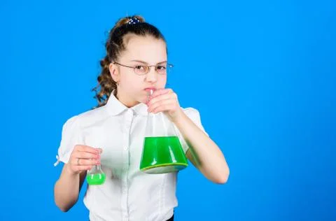 Child study bilogy lesson. small smart girl with testing flask. education and 库存照片