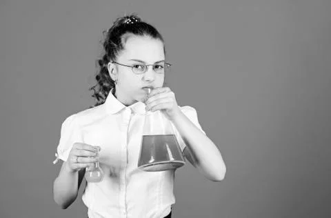 Child study bilogy lesson. small smart girl with testing flask. education and Stock Photos