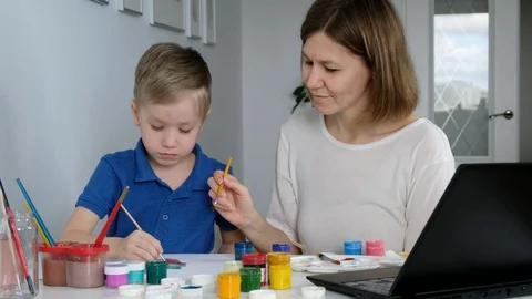 Child study online drawing with his mother via internet looking at laptop, Stock Footage 129324013