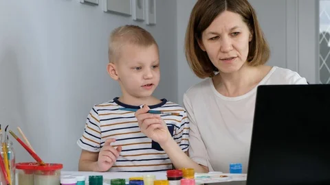 Child study online drawing with his mother via internet looking at laptop, Stock Footage 129324405