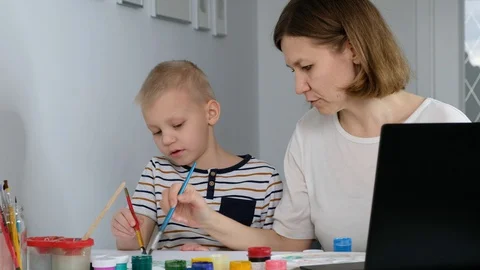 Child study online drawing with his mother via internet looking at laptop, Stock Footage 129486348