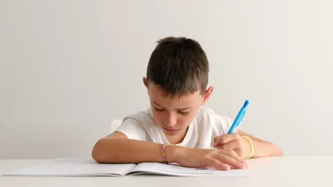Child studying and doing writing exercises. Concentration in children 库存影片 203845756