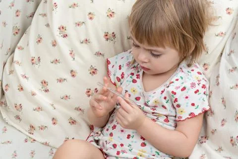 Child is studying temperature on thermometer Stock Photos