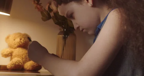 Child is studying while sitting at home in rays sun in room. Cute Kid in morning Stock Footage 265540093