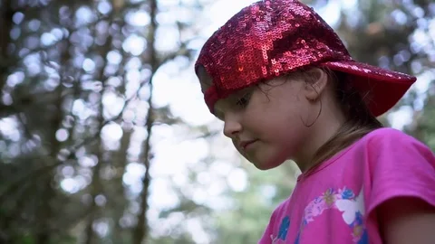 Child in a stylish baseball cap eat strawberries in the forest Stock Footage 78487395