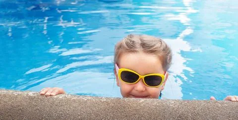 Child in sunglasses in the pool Stock Photos
