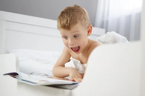 The child is surprised by what he has read in the new book. Stock Photos