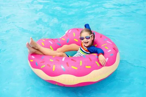 Child in swimming pool on donut float Stock Photos