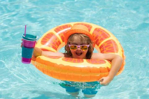 Child in swimming pool on inflatable float ring. Water toy, healthy outdoor 스톡 사진