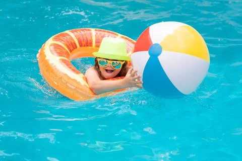 Child in swimming pool on inflatable float ring. Water toy, healthy outdoor Stock Photos