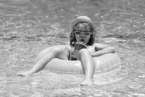 Child in swimming pool on inflatable float ring. Water toy, healthy outdoor Stock Photos