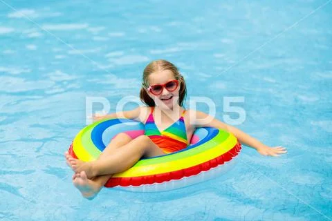 Child in swimming pool on toy ring. Kids swim. Stock Photos