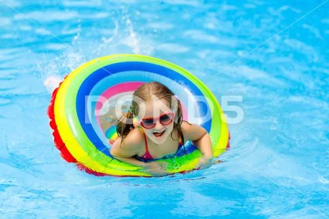 Child in swimming pool on toy ring. Kids swim. Stock Photos