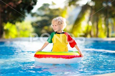 Child in swimming pool on toy ring. Kids swim. Stock Photos